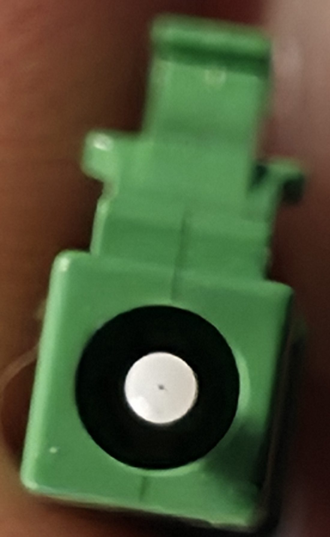 Stirnseite eines LC/APC-Steckers mit Ferrule, die Glasfaser als Punkt in der Mitte
